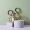 Five colored metal rings in green, pink, yellow and silver with a light background details Picture